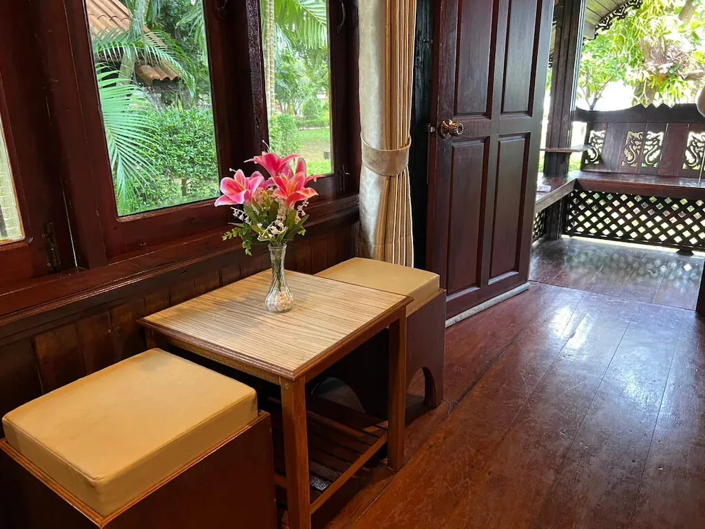 A cottage corner with a small table, fresh flowers and garden views