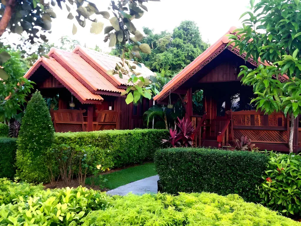 Cottages with terracotta roofs behind flowering hedges